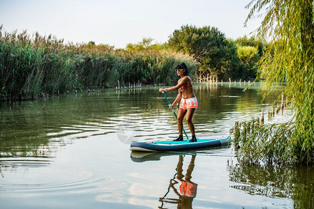 女子在湖上站着滑板年轻女孩在湖上渡水女游客在暑假时穿泳衣图片