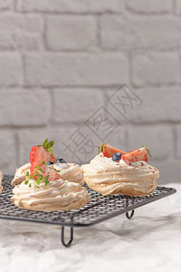小帕夫洛娃蛋糕配有新鲜的草莓和蓝图片