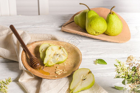 油腻的梨子有蜂蜜和坚果在木制桌上图片