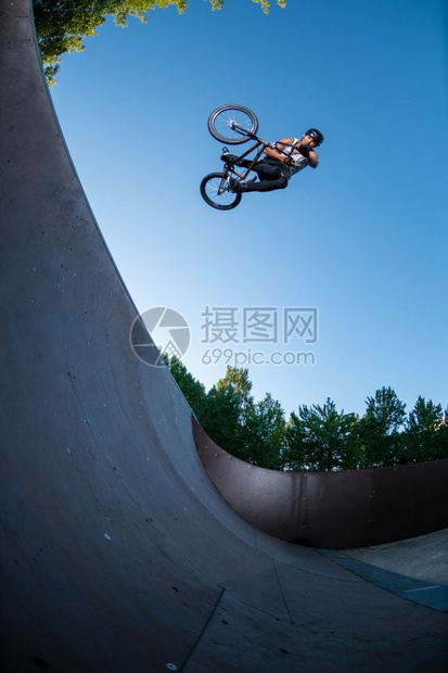 Bmx特技表演在滑板场的迷你坡道顶部图片