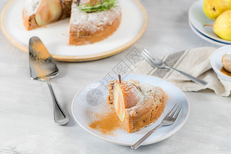 美味的蛋糕切片梨子姜汁和肉桂在一个盘子上黑暗的厨房柜台图片