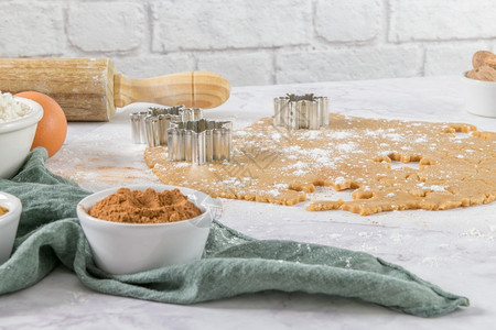 大理石厨房柜台上的圣诞饼干和剪刀的原始面粉图片