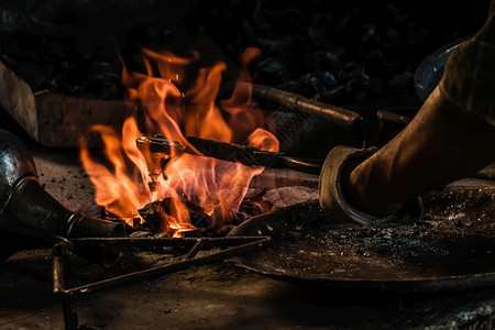 土耳其传统铁匠用火上喷洒的锡覆盖铜质物体背景图片