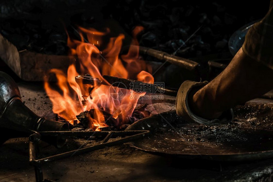 土耳其传统铁匠用火上喷洒的锡覆盖铜质物体图片