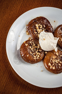 一种传统的无花果甜点配有奶油胡桃和白盘中的栗子图片