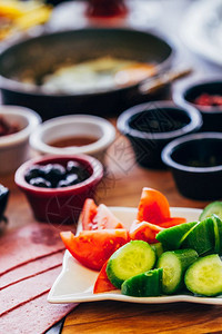 餐桌上有番茄黄瓜和黑橄榄的传统早餐菜图片