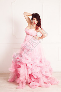 穿正式粉红裙子的美丽黑发女图片