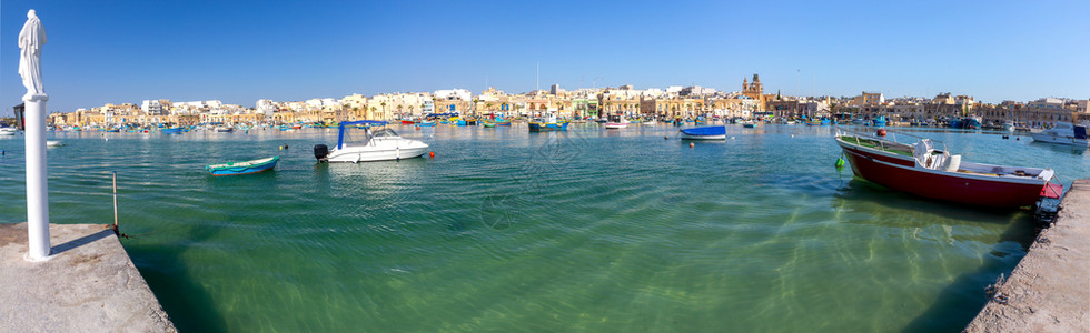 海湾渔船和马耳他Marsaxlokk村的全景图片
