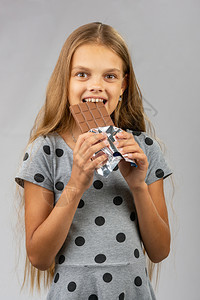 10岁女孩咬巧克力快乐地看着框架图片