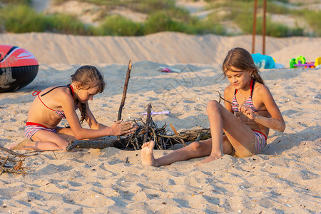 晚上在沙滩两个女孩准备放火的地方图片