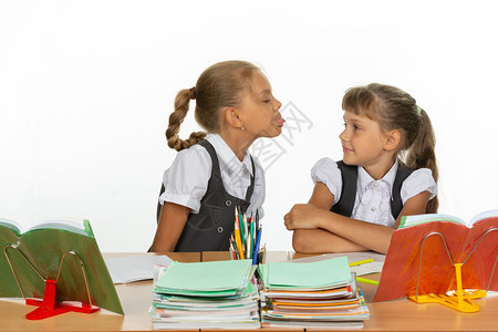 坐在桌上的女孩对另一个说舌头图片