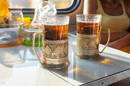 在车厢的桌子上有杯装金属的茶图片