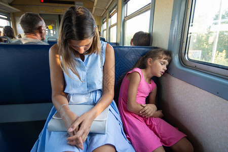 母亲和女儿疲累在电车列上睡得安稳图片