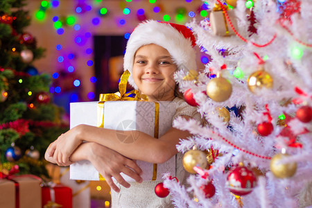 圣诞树上的女孩手里拿着大礼物图片