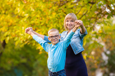 妈和儿子七岁在秋天公园玩得开心图片