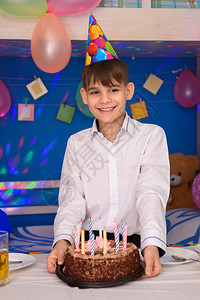 男孩拿着蛋糕站在桌子上背景图片