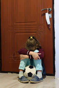 隔离期的女童在前门与一个球起坐着时遭受图片