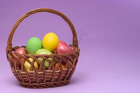 紫色背景的篮子里装满了彩色的蛋图片