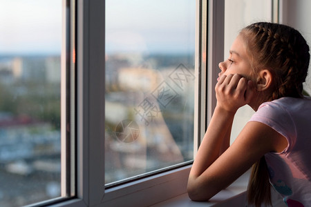 自孤立的女孩向窗外看图片