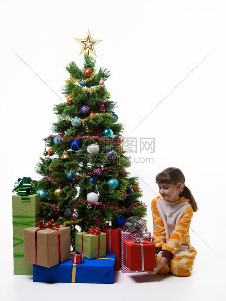 女孩从圣诞树下拿出礼物图片