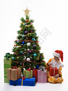 女孩在圣诞树上打开礼物图片