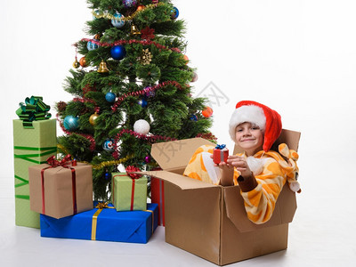 女孩爬上去坐在一个装饰圣诞树的盒子里图片