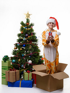 快乐的女孩手里拿着礼物站在盒子里储存圣诞玩具图片