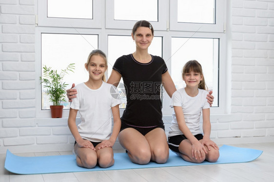 母亲和女儿在健身垫子上家里穿运动服的母亲和女儿图片
