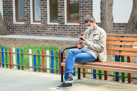 一个人在街上走蹲长凳看着电话屏幕图片