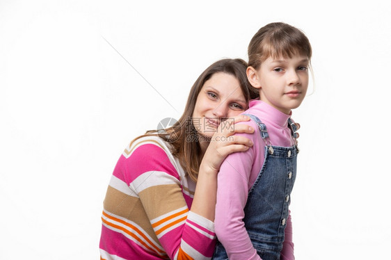 快乐的母亲把她头放在女儿背上孤立在白色背景上图片