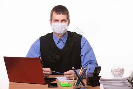 在工作场所戴着保护医疗面具的男办公室工作人员肖像图片