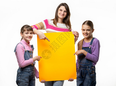 母亲和两个女儿手里握着一个橙色的标志指着它图片