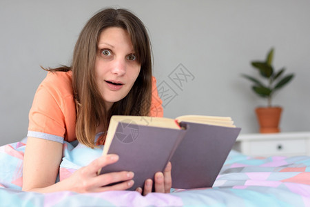 在一本书里读到时略受惊吓的女孩图片
