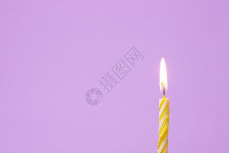 一个节日蜡烛被点亮浅紫色背景图片