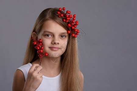 一个漂亮的十岁女孩肖像手拿着一堆浆果和头发图片