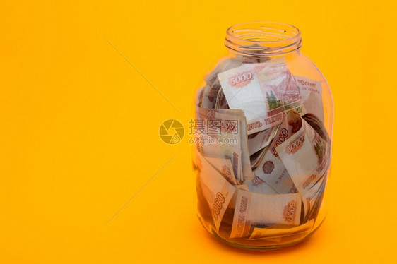 在玻璃杯里三升的罐子是五千张俄罗斯钞票图片