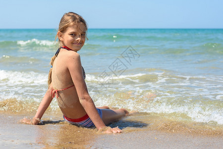女孩坐在沙滩上转过身来看框架图片