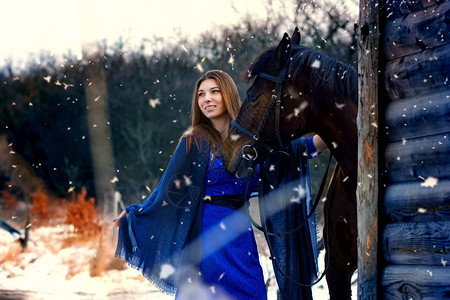 穿蓝衣服的漂亮女孩站在一匹马旁边木制建筑附近的一匹马图片