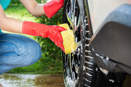 汽车精洗妇女用海绵洗车轮背景
