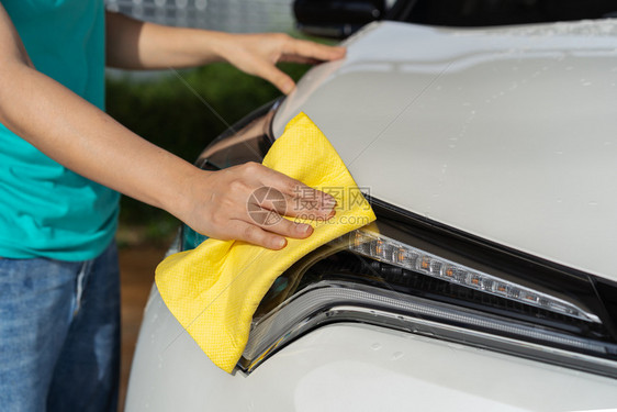 手和微纤维布清洗一辆汽车图片