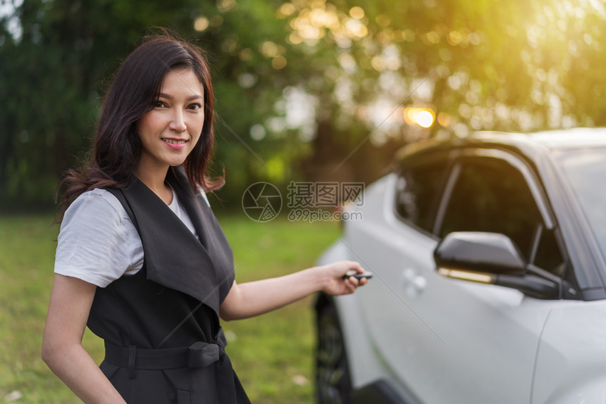 年轻女士用汽车携带智能钥匙遥控器图片