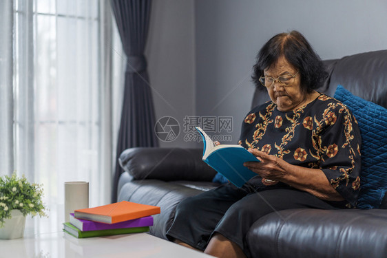 在客厅看书的年长妇女图片