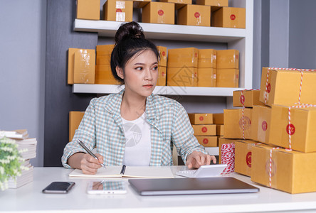 年轻女企业家在庭办公室计算财务在线市场包装箱交付开办小企业主图片
