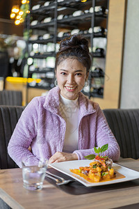 餐厅里有食物的年轻美女图片