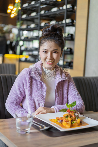 餐厅里有食物的年轻美女图片