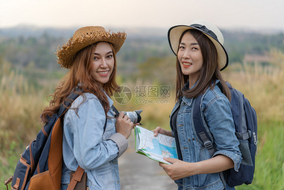 两名携带背包的女游客在农村旅图片