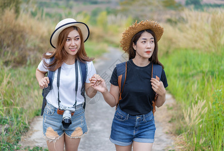 两名携带背包的女游客在农村旅图片