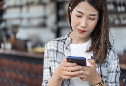 在咖啡馆里使用智能手机的快乐女人图片