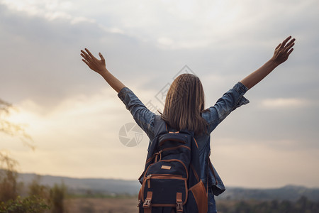 背着包的女旅行者手持举起的图片