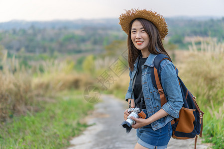 农村携带背和照相机的女游客图片